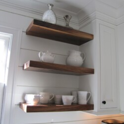Walnut shelves on pine shiplap walls