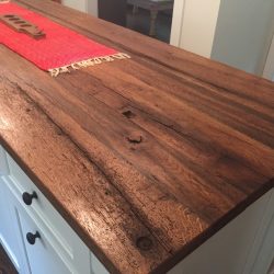 Rustic reclaimed wood island top makes this kitchen unique, casual and classy.